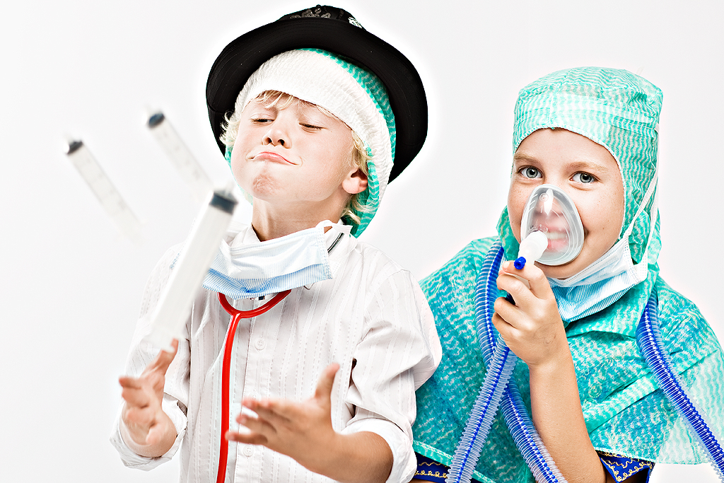 Boy and girl playing with syringes and anaesthesia mask.