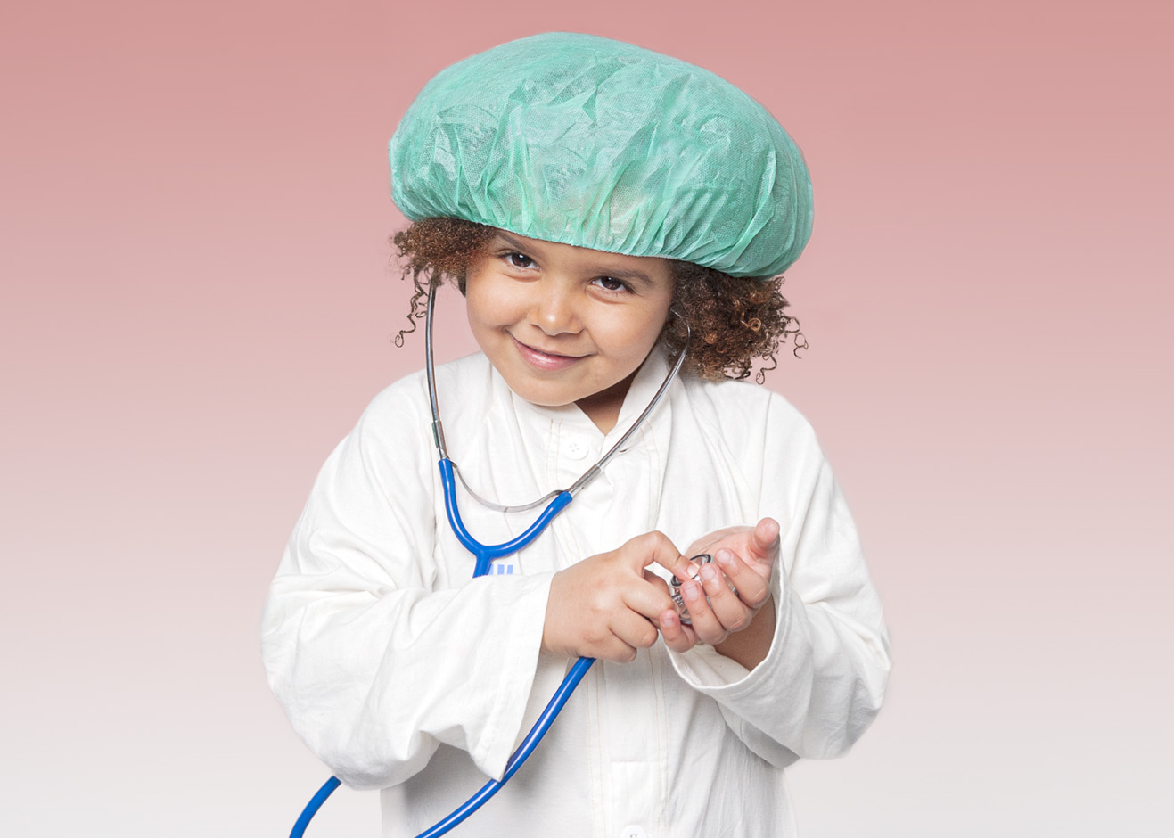Girl wearing a green scrub cap is listening with a stethoscope.