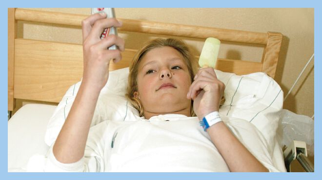 Ronja lies in her bed while eating ice cream and checking her phone.